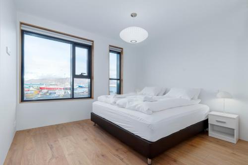 雷克雅未克Blue Viking Apartments Reykjavik的白色的卧室设有一张大床和一个窗户