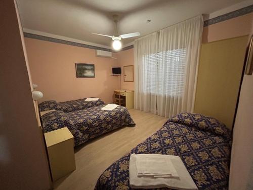 马萨罗萨玛尔妮酒店的酒店客房设有两张床和窗户。