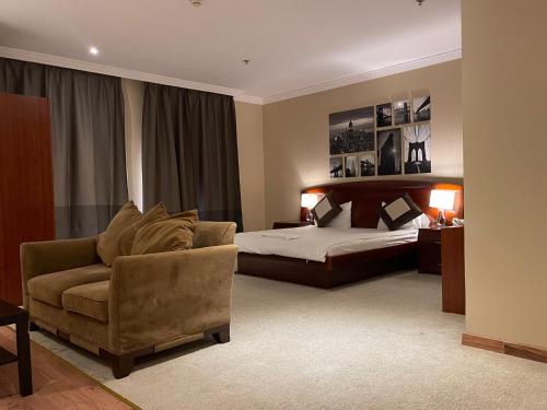 Al WakrahWakra Inn Hotel Apartments的一间卧室配有一张床、一张沙发和一把椅子