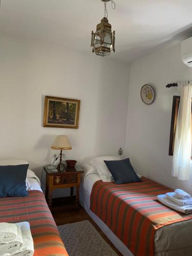 格拉纳达拉卡斯塔德尔喀拉隆旅馆的一间卧室配有两张床和一张带台灯的桌子
