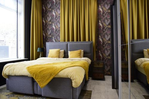 丽兹De Oude Pastorie Lisse的一间卧室配有一张黄色毯子床