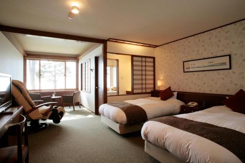 千岁Shikotsuko Onsen Lake Side Villa SUIMEIKAKU-Adult Only的酒店客房设有两张床和电视。