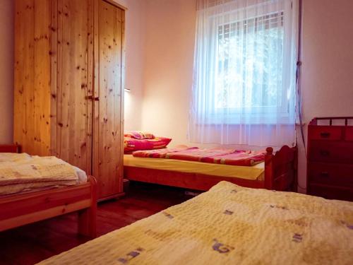 鲍洛通费尼韦什Apartment for 5 ppl at Lake Balaton的客房设有三张床、一个窗户和一个窗户。