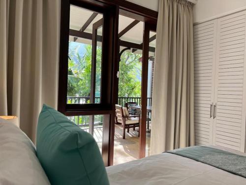 伊甸岛Waterfront Maison by Simply-Seychelles的一间卧室配有一张床,享有庭院的景色