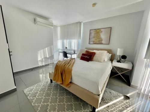 圣佩德罗苏拉Amplio condominio ejecutivo con hermosa vista的一间卧室配有一张床、一张桌子和一个窗户。