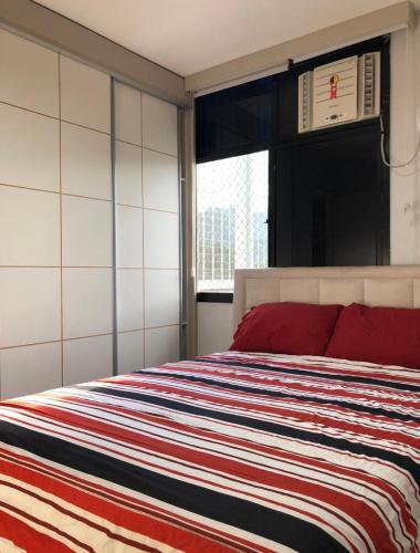 里约热内卢Casa Mag :)的一间卧室配有一张带彩色条纹毯子的床