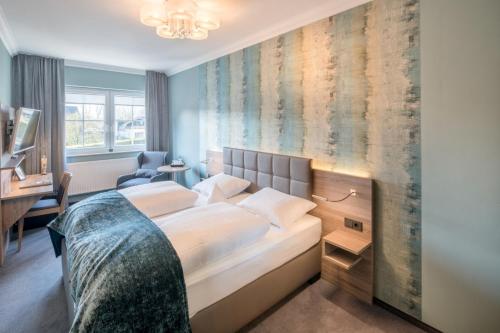 加瑞尔博思特酒店的一间卧室配有一张床和一张书桌