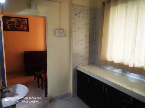 纳威孟买Hotel Royal Residency的一间带水槽的浴室和一个带浴缸的窗户。
