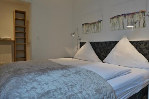 弗伦斯堡Ferienwohnung STADTBLICK的一间卧室配有一张带白色床单的大床