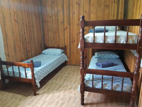 莫雷蒂斯Pousada Serra Verde Ecolodges的木墙客房的两张双层床