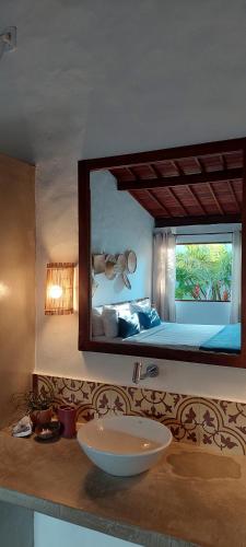 佩德拉斯港Arataba Hotel Boutique e Bistrô - 150 mts do mar的一间带水槽的浴室和一张带镜子的床