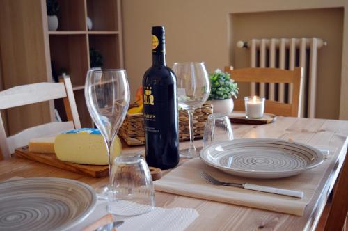 富切基奥Le Case di Sonia DEL CORSO CIV 25 Fucecchio的一张桌子,上面放着一瓶葡萄酒和酒杯