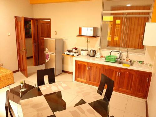 伊基托斯100 RV Apartments Iquitos-Apartamento primer piso con vista a piscina的厨房配有桌子和冰箱