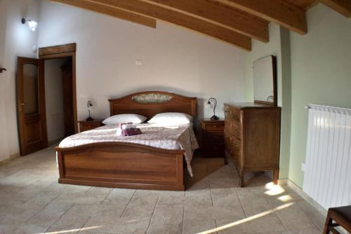 Ozzano Monferratob&b CASCINA SORTINA Country House的一间卧室配有木床和梳妆台