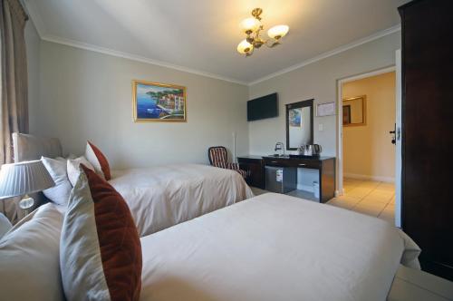 开普敦萨伏依酒店的酒店客房配有两张床和一张书桌