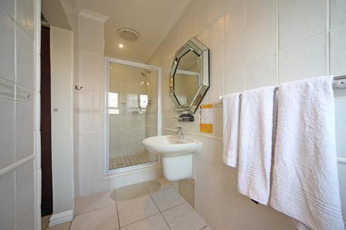 开普敦萨伏依酒店的白色的浴室设有水槽和淋浴。