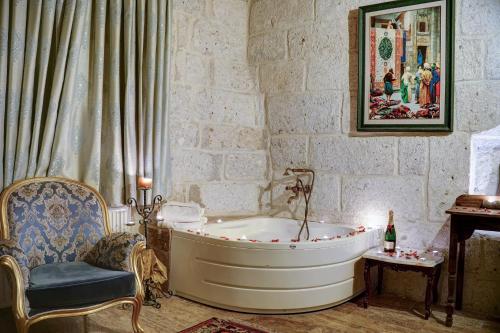 内夫谢希尔Mahperi Cappadocia Cave的带浴缸和椅子的浴室