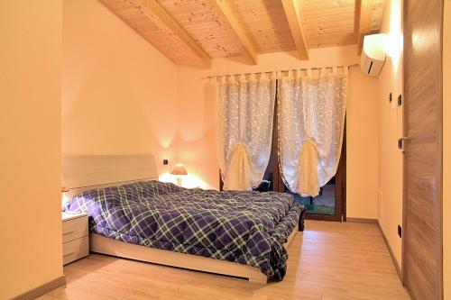 泰塞拉安格利图斯莫梅洛格拉诺酒店的一间卧室配有床和带窗帘的窗户