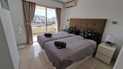 阿德耶Ocean View Apartment, Costa Adeje,Tenerife的一间卧室设有两张床和大窗户
