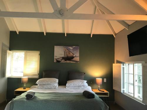 约翰内斯堡Aluve Guesthouse的一间卧室设有一张大床和两个窗户。