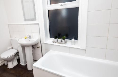 赫尔Cozyhouses的白色的浴室设有卫生间和水槽。