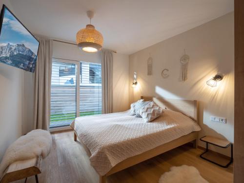 蒂罗尔州圣约翰Ferienwohnung "Tiroler Alpenzauber"的一间卧室设有一张床和一个大窗户