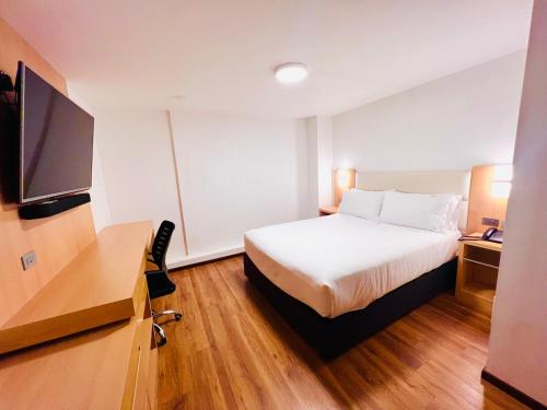 阿雷基帕OQ STANDARD HOTEL - Airport的配有一张床和一台平面电视的酒店客房