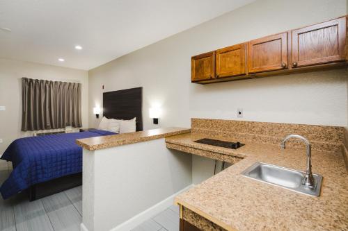 亨博尔温彻斯特套房饭店 - 汉布尔/乔治·布希洲际机场/北休斯顿的一个带水槽的厨房和一张位于客房内的床