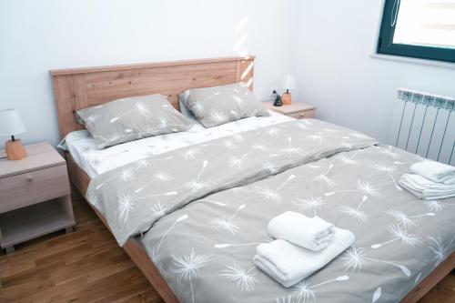 斯科普里Sunlight Apartment的一间卧室配有一张床,上面有两条毛巾