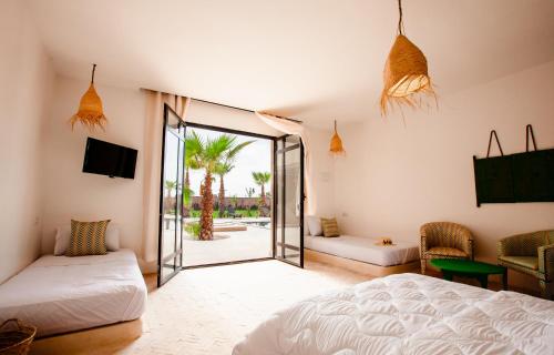 马拉喀什Aghmat Lodge Guest house的一间卧室设有一张床和一个滑动玻璃门