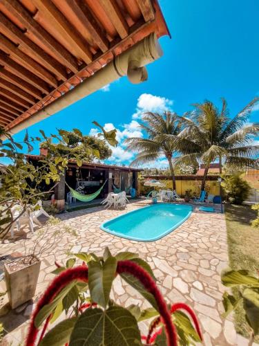 马拉戈日Aloha Beach Guest House的棕榈树庭院内的游泳池