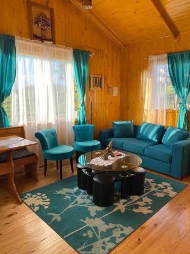 安库德Cabañas Agroturismo Pupelde的客厅配有蓝色的沙发和桌子