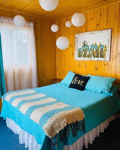 安库德Cabañas Agroturismo Pupelde的一间卧室配有一张带爱枕头的床
