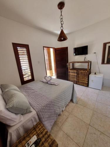 马拉戈日Aloha Beach Guest House的一间卧室配有一张大床和电视