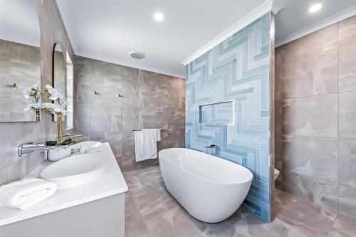 埃尔利海滩Cove 18 - Luxury beach house的浴室配有大型白色浴缸和水槽