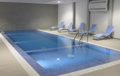 维拉多比斯坡米拉萨格雷斯酒店的一个带蓝色椅子的游泳池