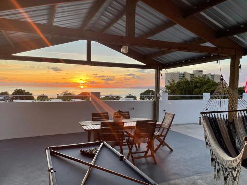 瓜尼卡Palmeras Beach Apartments - Playa Santa的一个带桌椅的庭院,享有日落美景。