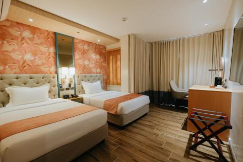 大雅台El Bien Hotel Tagaytay的酒店客房配有两张床和一张书桌