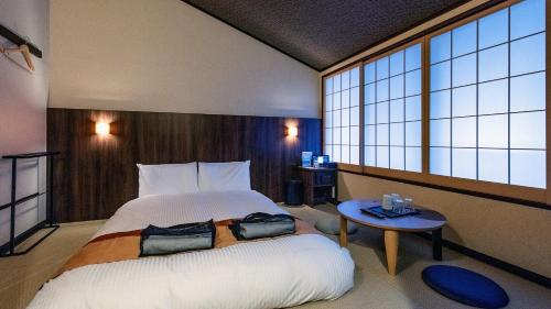 小田原市Tenseien Odawara Station Annex的一间卧室配有一张大床和一张桌子
