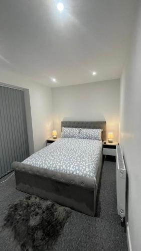 伦敦2 bed room luxury apartment in old Kent road London的一间卧室配有一张床、两张桌子和两盏灯。