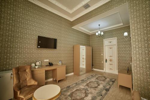 撒马尔罕Comfort Hotel Samarkand的客房设有书桌和墙上的电视。
