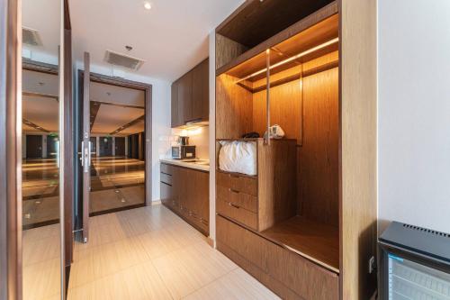 芽庄MySea Panorama Nha Trang Superview Apartments的厨房配有木制橱柜和步入式衣柜。