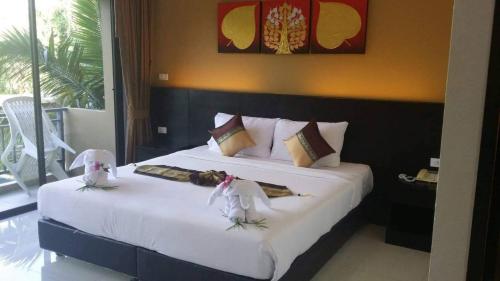 奈扬海滩Naiyang Beach Hotel SHA Plus的一间卧室配有一张带白色床单的大床