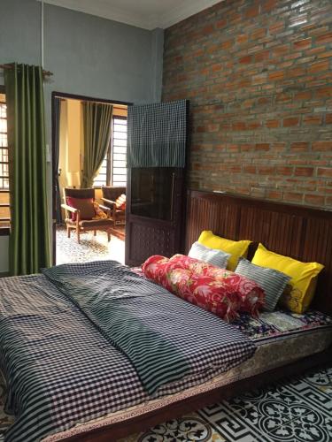 Silk Island Homestay的一间卧室设有一张床和砖墙