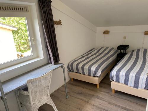 海牙Haags Duinhuis - familyfriendly holidayhome的带窗户的客房内的两张床