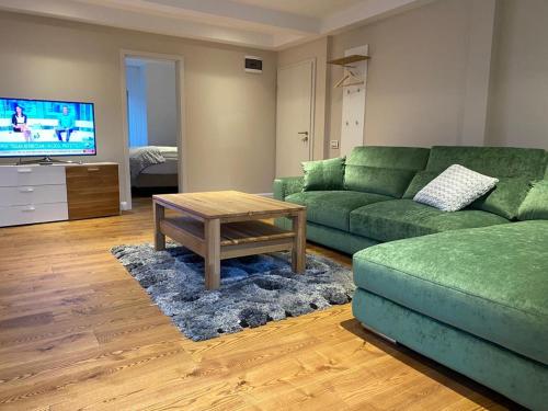 莱斯诺夫ApartamentS的客厅配有绿色沙发和茶几