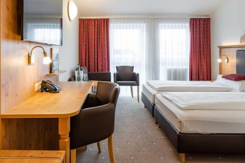 FensterbachHotel Wolfringmühle的酒店客房配有两张床和一张书桌