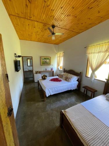 瓦尔任博尼塔Pousada Vale dos Diamantes的一间卧室设有两张床和木制天花板
