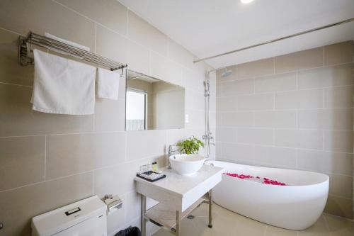富国The May Phu Quoc Hotel的浴室配有白色浴缸和水槽