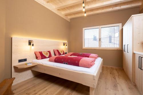NiederndorfBio-Chalet Haus Wagner的一间卧室配有一张带红色枕头的大床